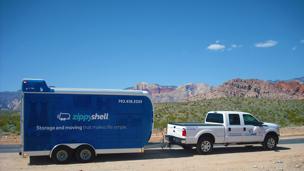 white zippyshell truck pulling blue trailer